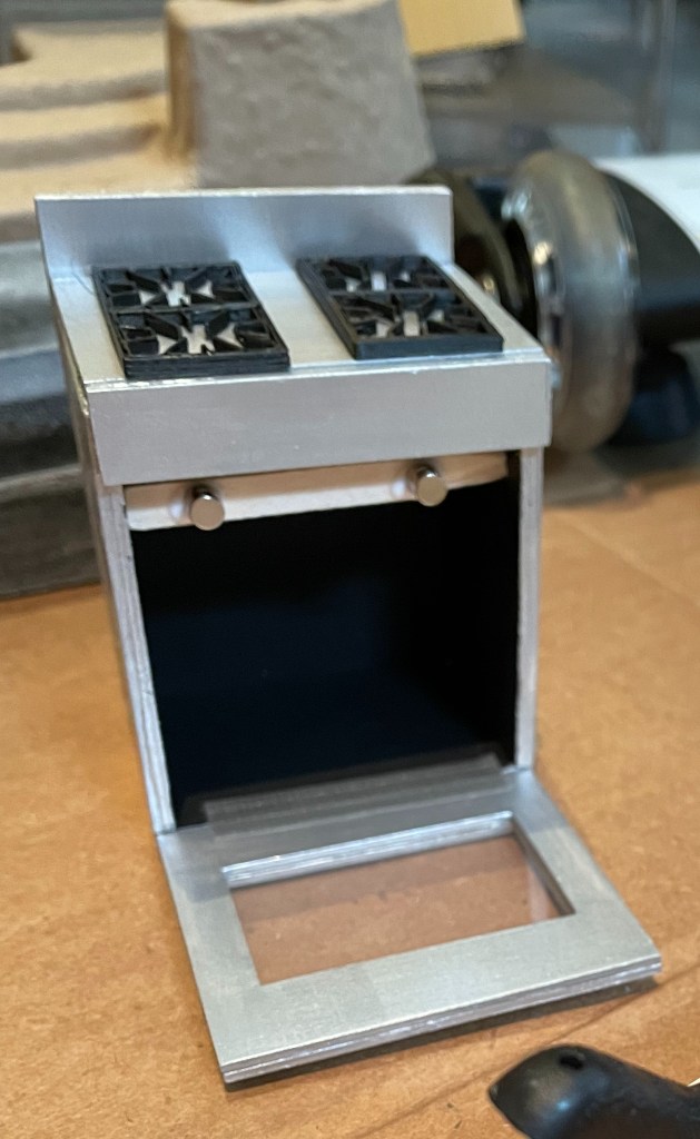 1:12 scale dollhouse stove in progress, with silver paint and black accents.  